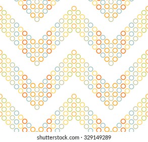 Seamless chevron pattern. Zigzag mosaic motif of colorful circles and rings on white background. Abstract wavy Background. Vector Illustration.
