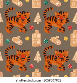 Seamless Christmas pattern with cute tigers, gingerbread and caramel on a beige background. Vector pattern. Festive background for fabric, clothing, wallpaper, wrapping paper, stationery.