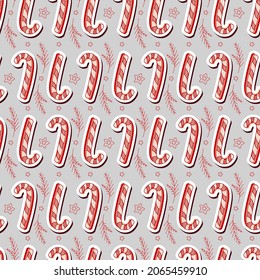 Seamless christmas vector pattern with candy canes, branches and stars on gray background. Vector holiday background. New Year mood. Design for winter holidays greeting season.