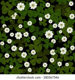 Seamless clover leaves and flowers pattern on black background at Patrick's Day 