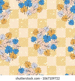 Seamless editable texture. Groups of colored leaves sketched on a diagonal-chess surface.