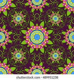 Seamless floral mandala pattern in pink, turquoise green and pale orange on floral lilac background.