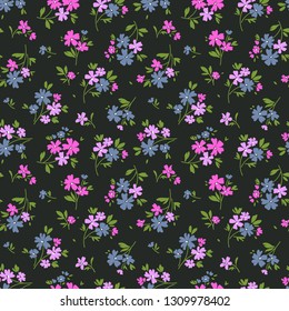 Seamless floral pattern for design. Small pink and purple flowers. Dark background. Modern floral texture. A allover floral design in bright colors. The elegant the template for fashion prints.
