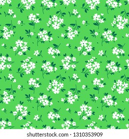Seamless floral pattern for design. Small white flowers. Bright green background. Modern floral texture. The elegant the template for fashion prints.