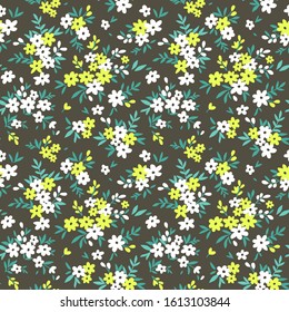 Seamless floral pattern for design. Small white ad yellow flowers. Dark gray background. Modern floral texture. A allover floral design in bright colors. The elegant the template for fashion prints.