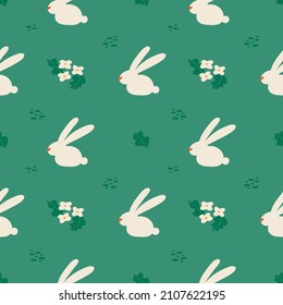 Seamless floral pattern with rabbits. Spring green background. Pattern for Easter. Modern stylish abstract vector illustration in flat style for wrapping paper, fabric printing.