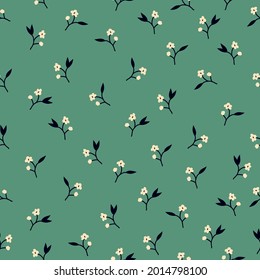 Seamless floral pattern. A small background of small milky flowers and black leaves. Small flowers scattered on a green background. Stock vector for printing on surfaces and web design.