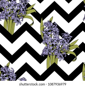 Seamless floral pattern. Violet Hyacinth flowers and leaves on a zig zag geometric background. Vector illustration.