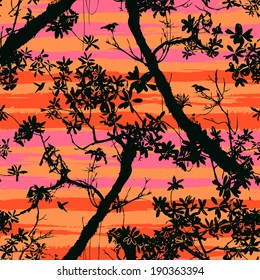 Seamless floral vector pattern inspired by plants and nature of jungle and rainforests, with silhouettes of tropical trees and leaves, small birds and hummingbirds in black on sunset orange colors