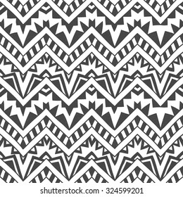 Seamless geometric background. Grey zigzags on a white background. Handmade. Ethnic ornament, tribal motifs.