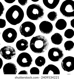 Seamless geometric pattern with bold brush drawn circles. Grunge vector circular brush strokes. Black round paint stamps. Ink geometric texture. Naive motif abstract wallpaper with various bold dots.