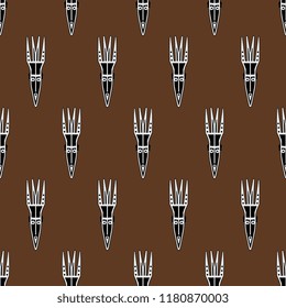 Seamless geometrical pattern with silhouettes of African masks.