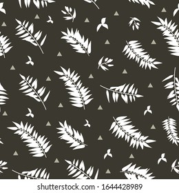 Seamless graphic pattern with the image of white palm leaves on a black background. Vector illustration
