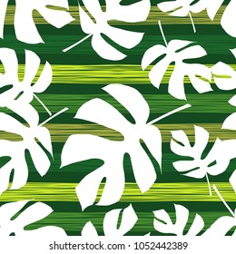 Seamless green background with decorative white leaves. Pattern with Palm leaves. Scribble texture. Textile rapport.