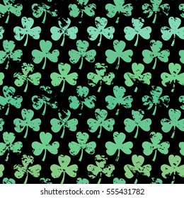 Seamless green grunge clover pattern on a black background