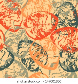 Seamless grunge pattern with colorful leaves on orange background