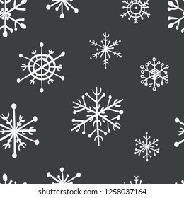 Seamless hand drawn snowflakes pattern on black background. Vector Illustration.