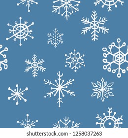 Seamless hand drawn snowflakes pattern on blue background. Vector Illustration.