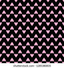 Seamless hearts pattern in pastel pink over black. Valentine's day tile background. Romantic vector pattern.