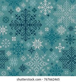 Seamless knitted pattern of white and turquoise snowflakes.Knitted texture.