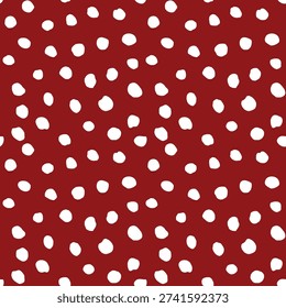 Seamless micro polka dot vector pattern with irregular organic white dots scattered on a burgundy red background for fabric, fashion textiles, wallpaper, wrapping paper, packaging and surface design.