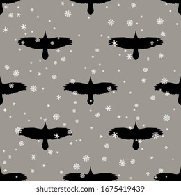 Seamless monochrome animal pattern with silhouettes of soaring raven or crow birds and snowflakes.