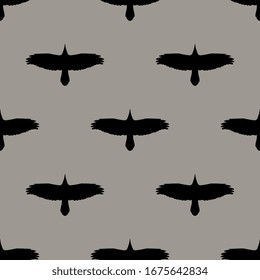 Seamless monochrome animal pattern with silhouettes of soaring raven or crow birds.