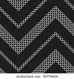 Seamless monochrome chevron pattern. Zigzag mosaic motif of white circles on black background. Abstract tracery wavy Background. Vector Illustration.