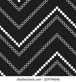 Seamless monochrome chevron pattern. Zigzag mosaic motif of white circles and dots on black background. Abstract dotted wavy Background. Chains. Simple Garlands. Vector Illustration.
