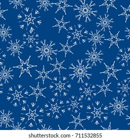Seamless pattern with abstract snowflakes on blue background. Chaotic, random, scattered winter motives. Vector illustration.