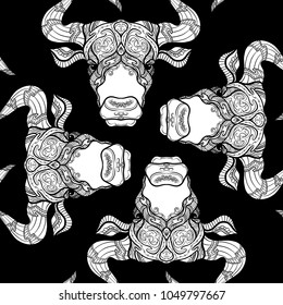 Seamless pattern, background with ethnic patterned ornate hand drawn head of Taurus, bull, ox in white on black background . 