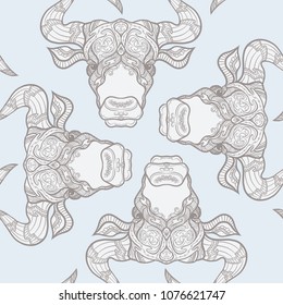 Seamless pattern, background with ethnic patterned ornate hand drawn head of Taurus, bull, ox. On blue vintage  background. 