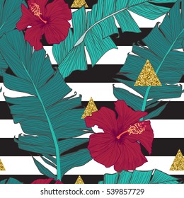 Seamless pattern with banana leaves, tropical flowers and geometrical golden elements

