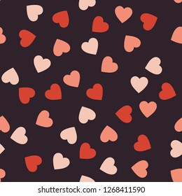 Seamless pattern from beautiful serdts of pink color against a dark background for the celebration of St. Valentine's Day.  Wallpaper for season decoration, wrapp paper, clothes prints. Flat design.