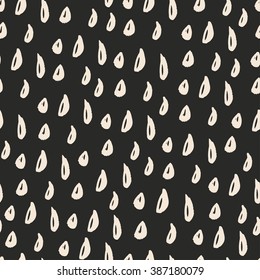 Seamless pattern of beige drops on dark grey background.