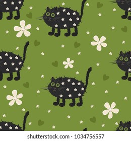 Seamless pattern of black cats, hearts and flowers on a green background
