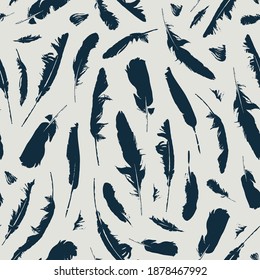 Seamless pattern with black feathers on a beige backdrop. Vector repeating background with bird plumes. Suitable for wallpaper, wrapping paper, fabric