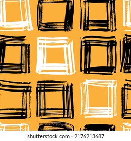 Seamless pattern from black and white squares from brushstrokes on orange background
