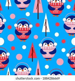 Seamless pattern with blue baby penguins wearing pink, red and white sweaters, hats and headphones. Blue background. Fir trees. Merry Christmas. Wallpaper, textile, scrapbooking and wrapping paper