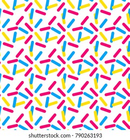 Seamless pattern of blue, pink, and yellow sprinkles.