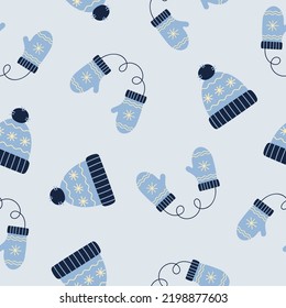 Seamless pattern of blue winter hat and mittens. Winter elements on blue background. Doodle style. Vector illustration