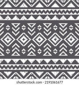 Seamless pattern in boho style. Vector wallpaper with ethnic aztec ornament in grey shades. Aztec abstract pattern. Folk stylized print template with shabby grunge effect.