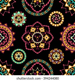 Seamless pattern of bright colorful geometric round ethnic decorative elements. Vector mandala background with bohemian, Oriental, Indian, Arabic, Aztec motifs.