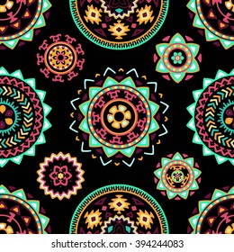 Seamless pattern of bright colorful geometric round ethnic decorative elements. Vector mandala background with bohemian, Oriental, Indian, Arabic, Aztec motifs.