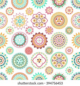 Seamless pattern of bright colorful geometric round ethnic decorative elements. Vector mandala background with bohemian, Oriental, Indian, Arabic, Aztec motifs.