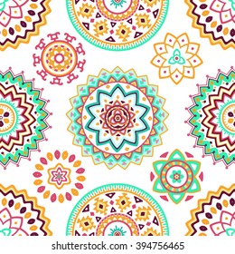 Seamless pattern of bright colorful geometric round ethnic decorative elements. Vector mandala background with bohemian, Oriental, Indian, Arabic, Aztec motifs.