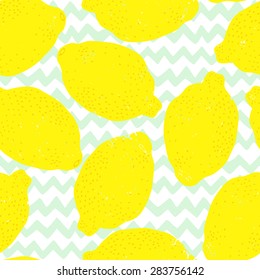 Seamless pattern with bright grunge textured lemons on hand drawn chevron background. Food tiling background.
