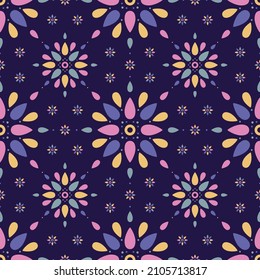 Seamless pattern of brightly coloured simple mandala shapes on a dark blue background.
