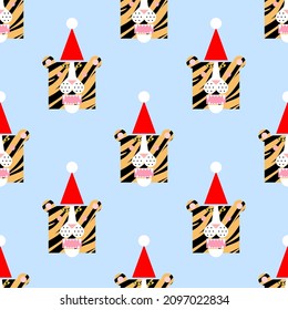 Seamless pattern with cartoon tiger head wearing a Christmas hat. Festive background or print.