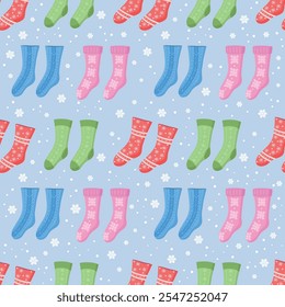 Seamless pattern with Christmas socks and snowflakes. Socks in different colors and ornaments. Red, blue, pink, green. Stockings for holiday projects, gift wrapping, textiles and seasonal design.